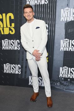 a man in a white suit and brown shoes at the cmt music awards on stage