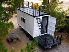 a tiny house built into the side of a forest with stairs leading up to it