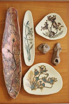 three different types of decorative plates on a wooden table with flowers and plants painted on them