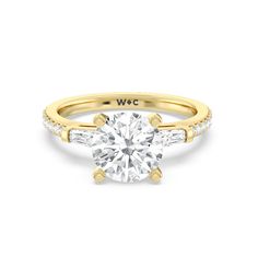 a yellow gold engagement ring with two side stones