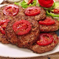 hamburger patties with tomatoes and lettuce on a plate