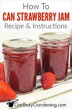 three jars filled with jam and strawberries on top of a towel next to each other