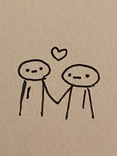 two people are holding hands with a heart drawn on the wall behind them in black ink