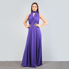 a woman in a purple dress poses for the camera with her hands on her hips