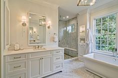 a large bathroom with two sinks and a bathtub next to a walk in shower