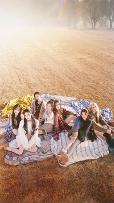 a group of young women sitting on top of a blanket