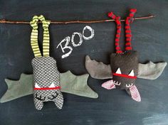 three stuffed animals are hanging on a rope with the word boo spelled in white chalk