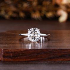 an oval cut diamond sits on top of a wooden surface