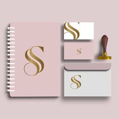 the letter s is inscribed in gold on a pink background