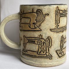 a coffee mug with an image of sewing machines on it's front and sides