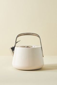 a white tea kettle sitting on top of a table