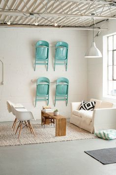 a living room filled with furniture next to a white brick wall and ceiling covered in metal beams