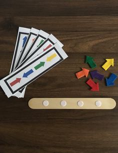 wooden pegs and colored arrows on top of a wood table with magnets in the shape of an arrow