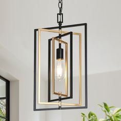 a black and gold chandelier hanging from a ceiling in a room with white walls