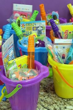 there are many toys in the buckets on the counter top, including pens and pencils