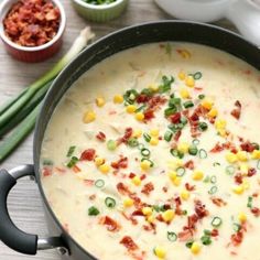 a skillet filled with corn and cheese on top of a table next to other ingredients