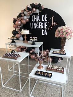 the dessert table is set up with black, white and gold balloons on top of it