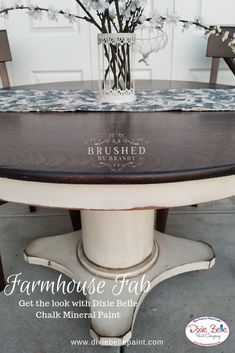 the farmhouse table is painted white and has flowers in a vase on top of it