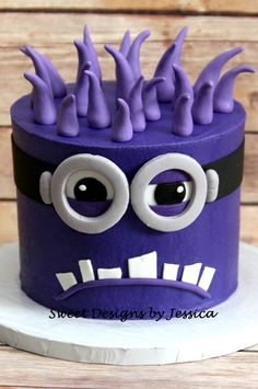 a purple and black cake with googly eyes