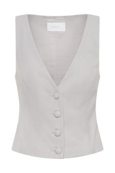 Clean-cut.Elevate your wardrobe with the ASPEN Suiting Vest, a sophisticated piece that seamlessly combines classic tailoring with modern style. Featuring a sleek V neckline and a button front closure, this sleeveless vest offers a streamlined, longline silhouette that flatters every figure. The versatile design makes it an essential addition to any ensemble, perfect for layering over blouses or pairing with the Penelope Pleated High Waisted Pants. Together, these pieces create a polished, cohes Luxury Tailored Vest With Buttons, Chic Tailored Single-breasted Vest, Elegant Single-breasted V-neck Vest, Luxury Tailored Single-breasted Vest, Tailored Single-button Vest, Capsule Wardrobe Accessories, Workwear Capsule Wardrobe, Workwear Capsule, Capsule Wardrobe Basics