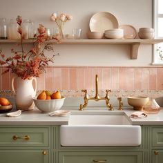 a kitchen with green cabinets and gold faucet, white counter tops, pink tile backsplash