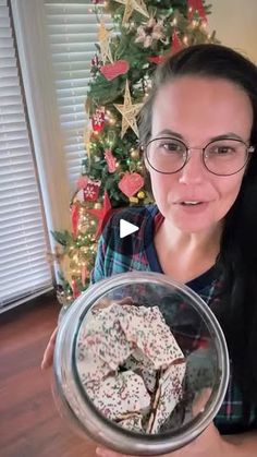 a woman holding up a bowl filled with cookies