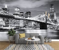 a living room with a couch, coffee table and large cityscape on the wall