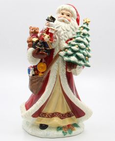 a santa clause figurine holding a christmas tree