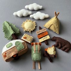 an assortment of handmade felt items including campers, tents and trees on a table