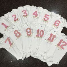 a group of white shirts with pink numbers on them