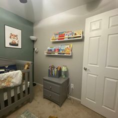 a baby's room with grey walls and gray furniture, including a crib