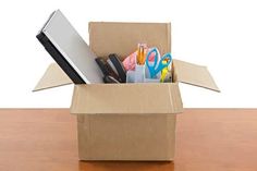 an open cardboard box filled with office supplies