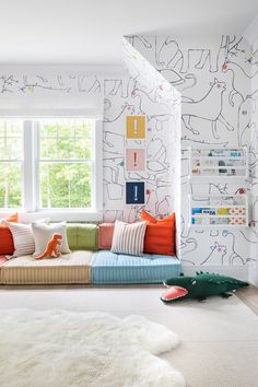 a living room filled with lots of furniture and pillows on top of white rugs