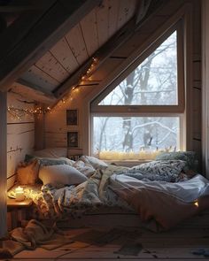 an attic bedroom with lights on the windows and blankets, pillows and blankets are laid out