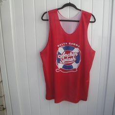 a red tank top hanging on a white door