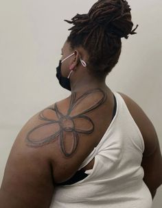 a woman with tattoos on her back and neck