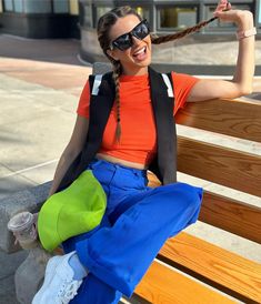 a woman sitting on top of a wooden bench