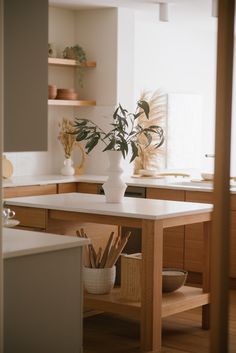 a white vase filled with flowers on top of a kitchen counter