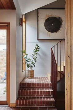 an entry way with stairs and potted plant