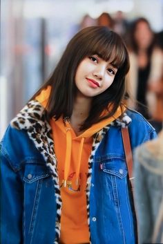 a young woman wearing an orange shirt and blue jacket