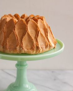 a bundt cake sitting on top of a green cake platter with frosting