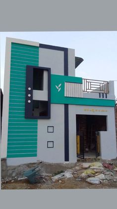 a large white and blue building with a balcony on the top floor that has stairs going up to it