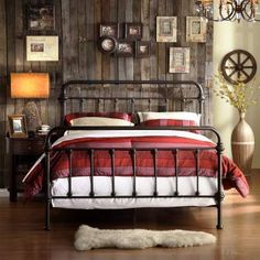 a bed with red and white bedspread sitting next to a wooden wall