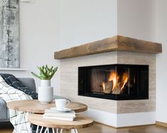 a living room with a fire place next to a couch and coffee table in front of it