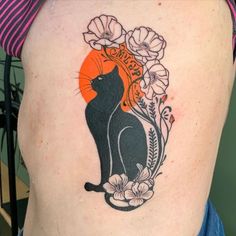 a woman with a tattoo on her stomach has a cat and flowers in the background