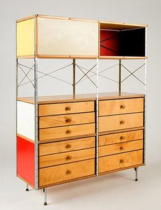 a wooden dresser with two different colored drawers on each side and an open shelf above it