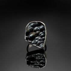 "A strange and strangely beautiful ring of raw botryoidal hematite full of bubbly surfaces and organic asymmetrical shape. This completely unique and one of a kind gemstone is all natural in its black on black globular surface, alternately satiny and shiny textures, and silvery-black tonal bubbles reflecting across a spherical surface. Some rusty red zones, particularly in the crevices between the orbicular spheres, indicates the presence of iron which oxidizes to a deep, orange red. Fascinating Modern Hand Forged Black Rings, Unique Black Ring With Oxidized Finish, Unique Black Oxidized Finish Ring, Brutalist Oxidized Finish Ring As Gift, Dark Rings, Red Zone, Yellow Rings, Moon Ring, Dark Matter