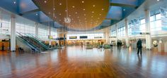 the inside of a large building with wooden floors and high ceiling lights hanging from the ceiling