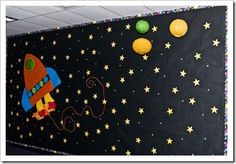 a space themed bulletin board with paper lanterns and stars on the outer part of it