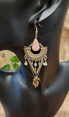 These beautiful, Peruvian, handmade earrings are just what you've been looking for. They have pink onyx and quartz gemstones in metal settings and dangle so elegantly in the wind. The design is so intricate, yet simple and only adds to the detailing of the earrings. They measure approximately 4" long x 1.25" wide. These are handmade and used, thus will have variations throughout and some noticeable wear, but they are otherwise absolutely beautiful. Bohemian Long Drop Chandelier Earrings Nickel Free, Elegant Long Drop Earrings For Festivals, Pink Teardrop Jewelry For Festivals, Bohemian Teardrop Crystal Earrings For Pierced Ears, Bohemian Long Drop Pierced Jewelry, Bohemian Style Pierced Crystal Earrings For Gifts, Bohemian Style Crystal Pierced Earrings For Gift, Bohemian Style Crystal Earrings As Gift, Handmade Elegant Pink Danglers